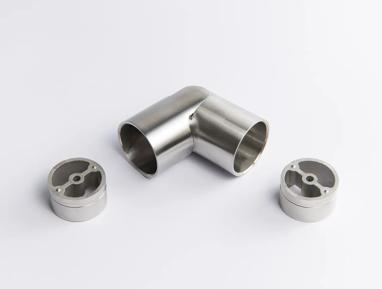 A flexible Stainless Steel metal tube connector positioned between two silver circular mounting inserts 43mm