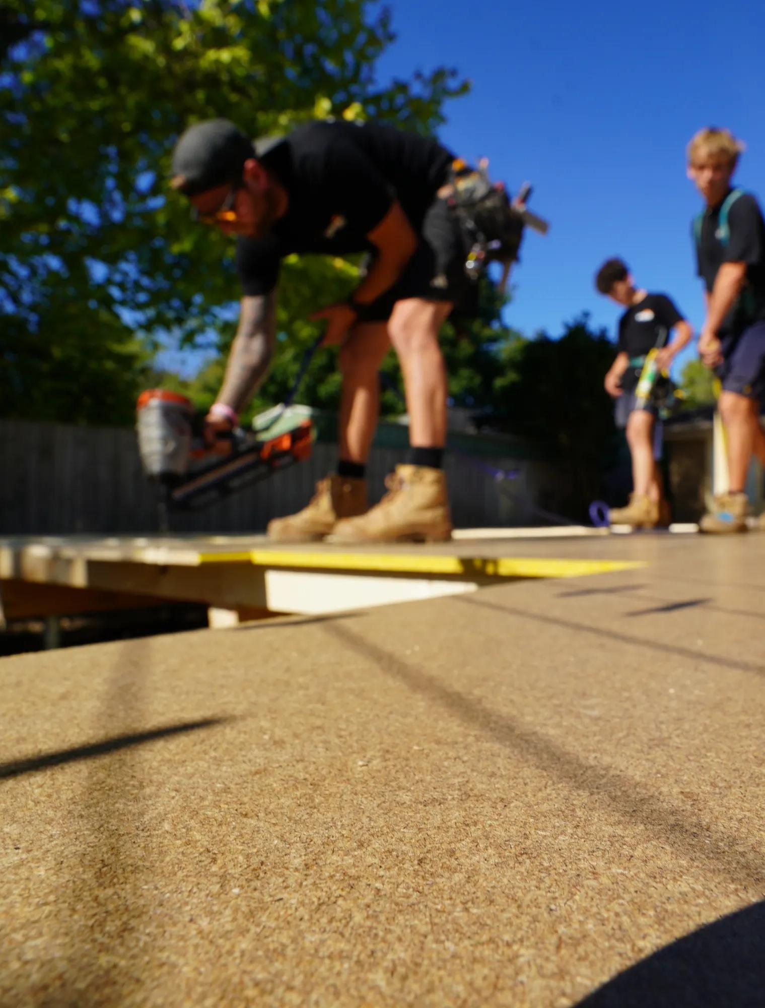 Workers installing Porta decking on an outdoor raised platform