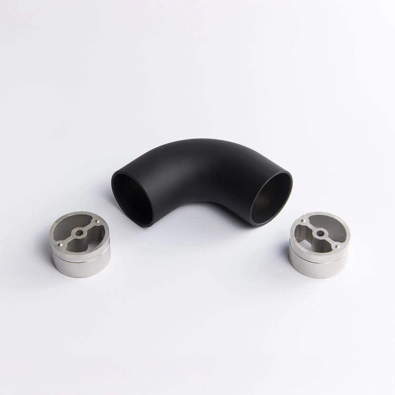 A fixed 90 degree black metal tube connector positioned between two silver circular mounting inserts 65mm x 43mm