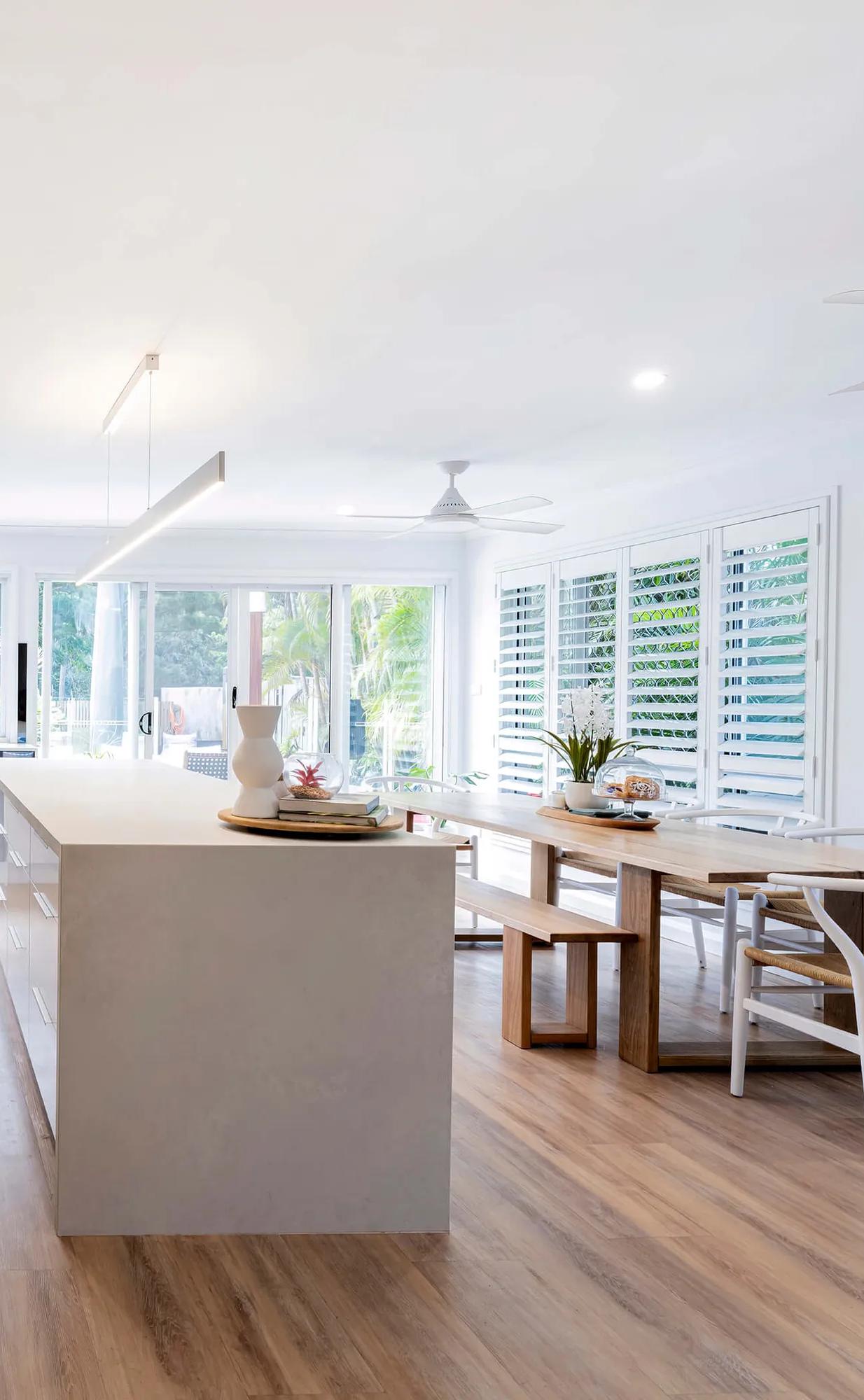 Large open room with white walls, wooden paneling, and modern appliances