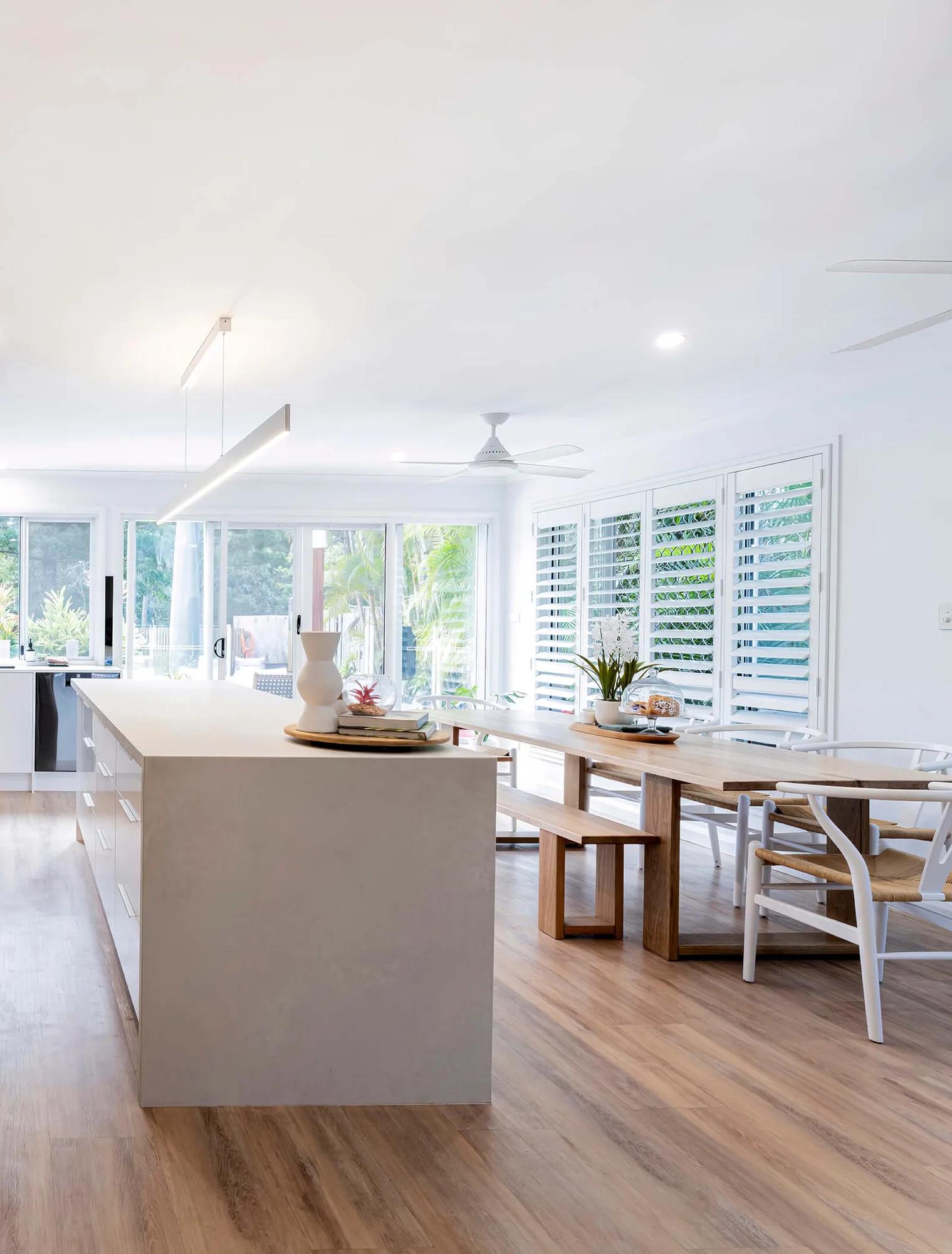 Large open room with white walls, wooden paneling, and modern appliances