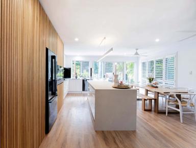 Large open room with white walls, wooden paneling, and modern appliances