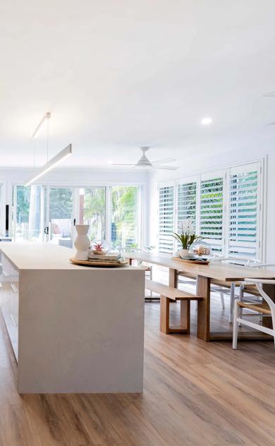 Large open room with white walls, wooden paneling, and modern appliances