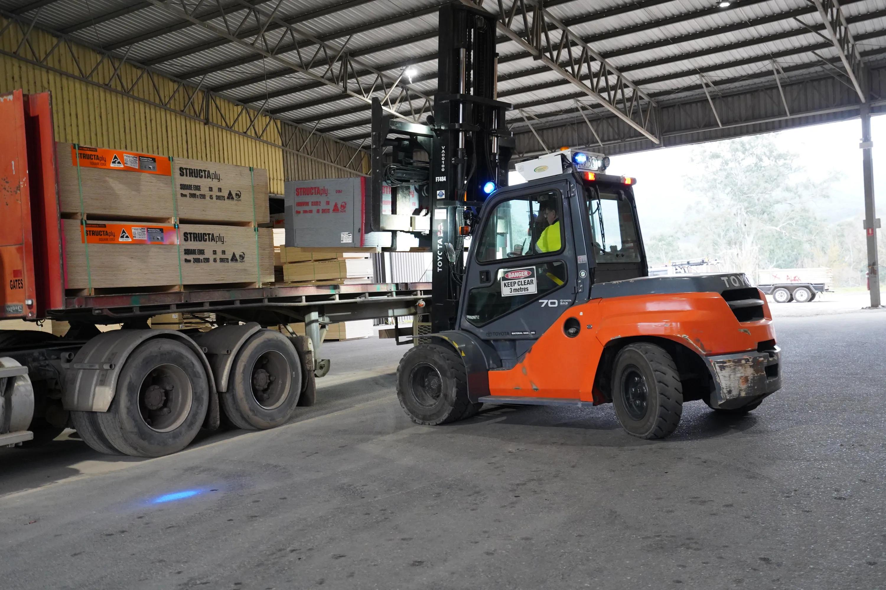 Forklift loading STRUCTAply sheets onto a truck inside a warehouse