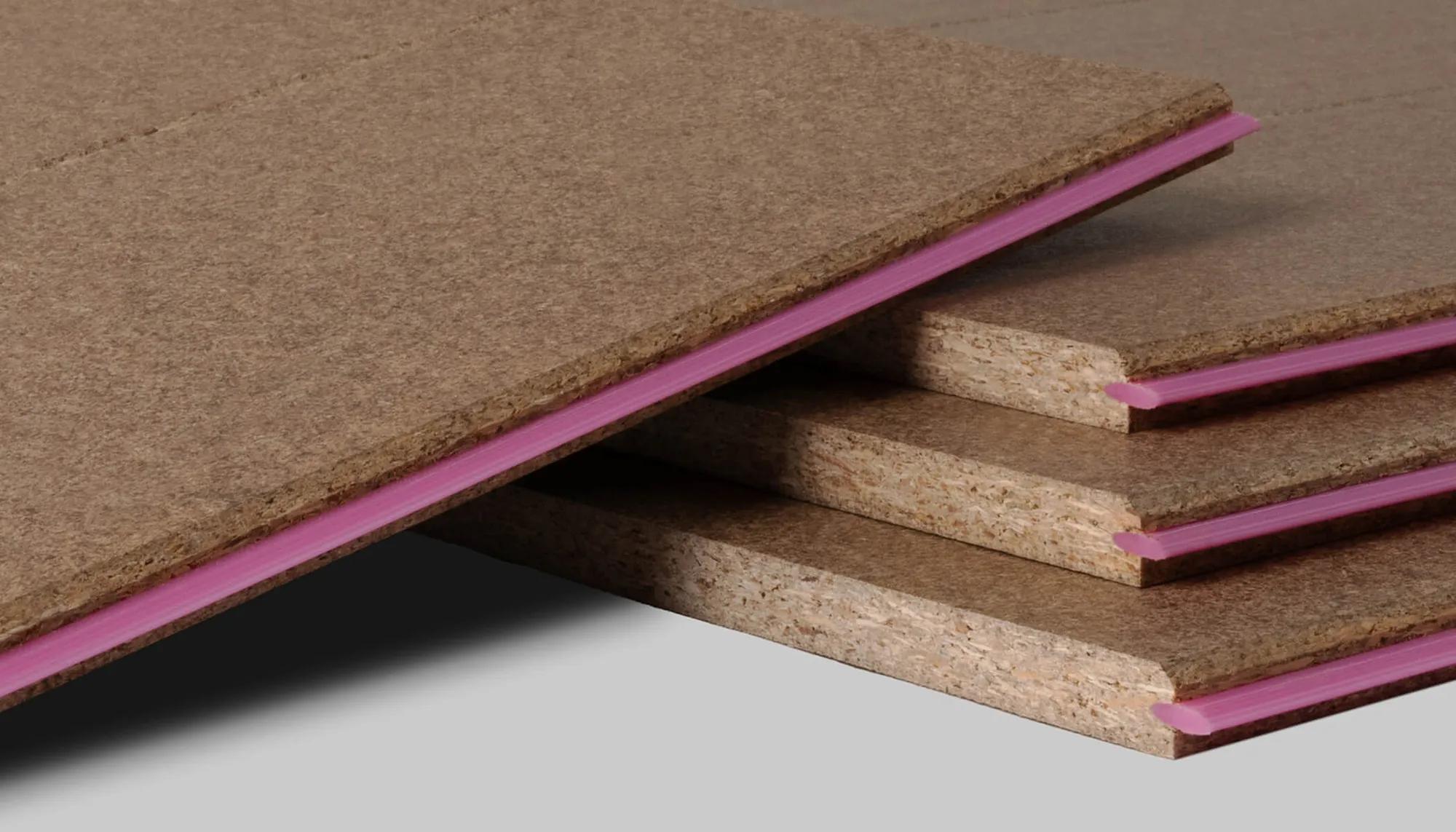 Close up of a stack of STRUCTApanel particleboards, showing the pink tongue edge on the right hand side
