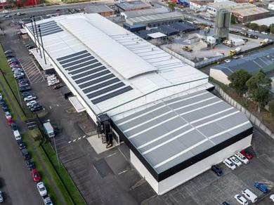 This is an aerial view of a warehouse with solar panels on the roof