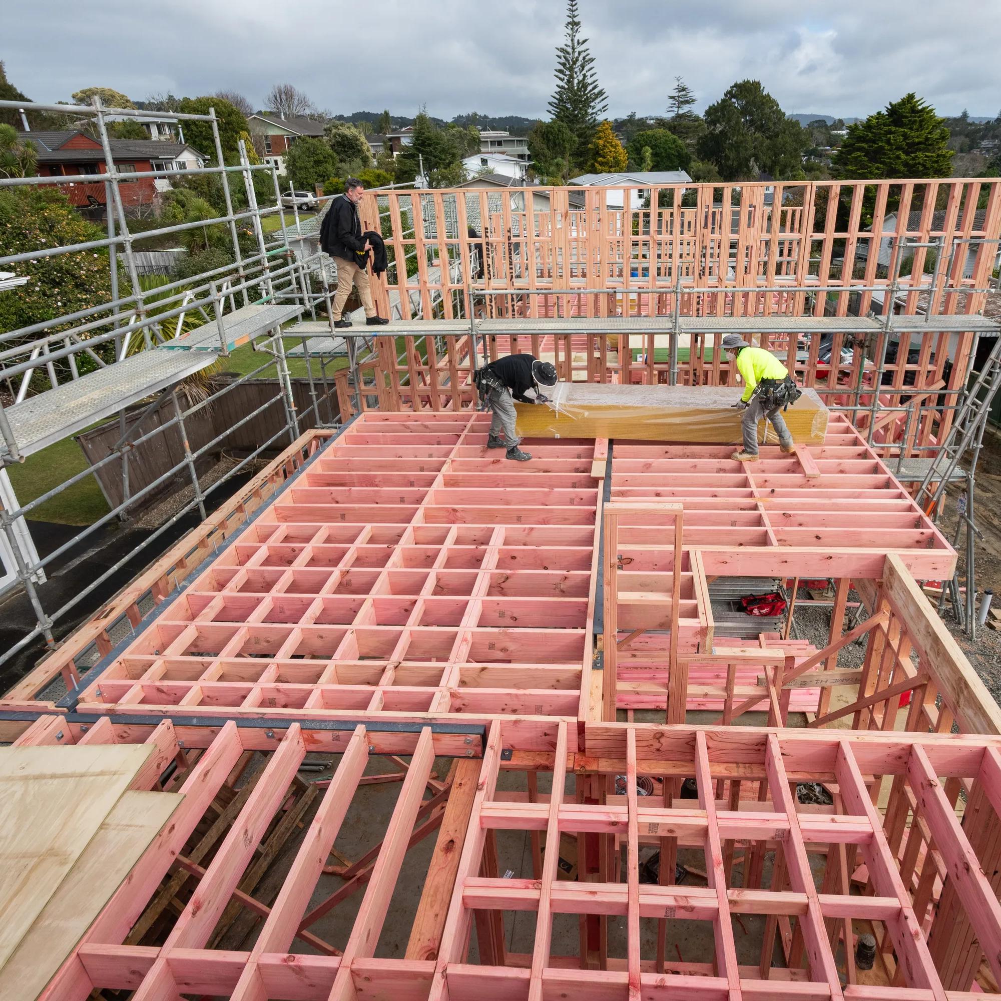 Workers constructing a timber-framed house on a residential building site