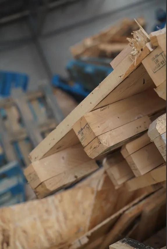 Close-up of stacked timber pallets in warehouse ready for recycling.