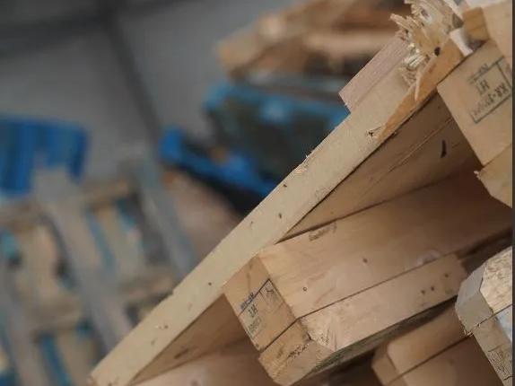 Close-up of stacked timber pallets in warehouse ready for recycling.