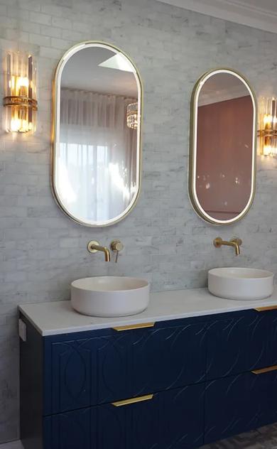 This is a bathroom. The bathroom has a dark blue sink countertop. There are two sinks in the image. The walls are tiled