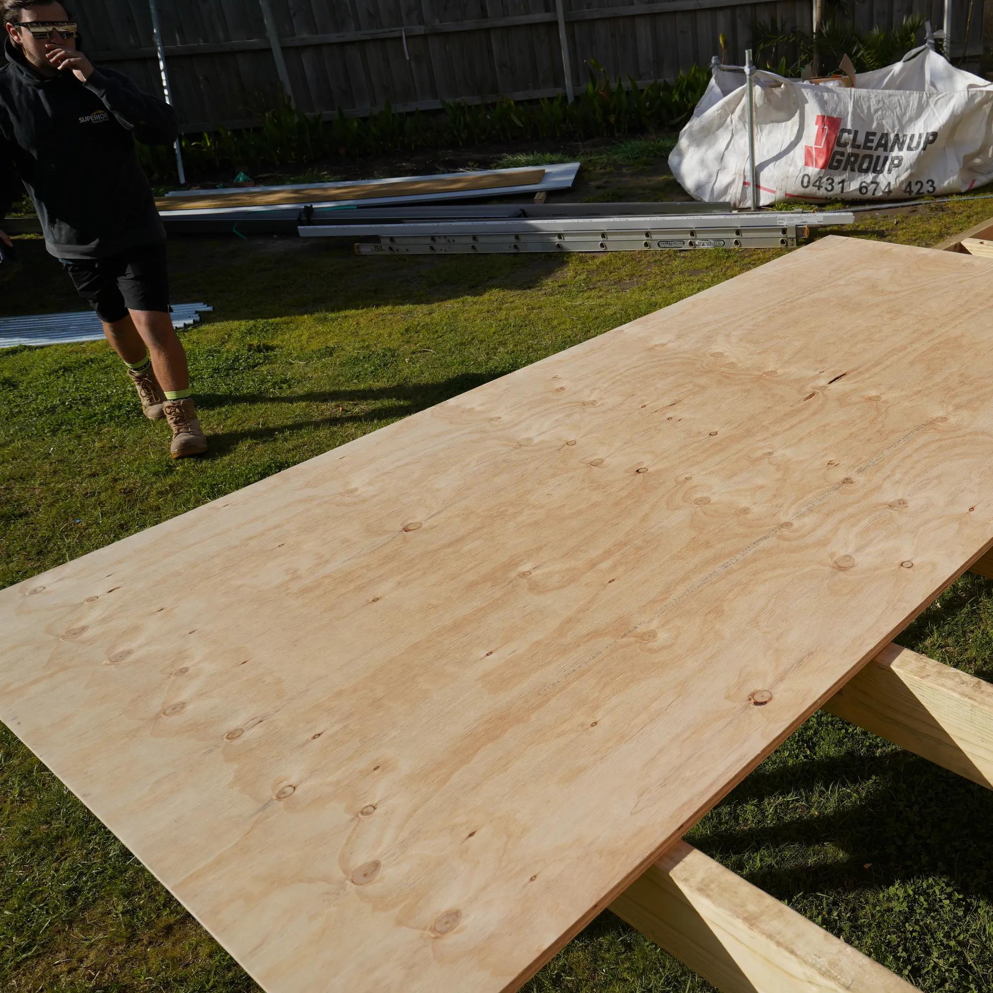 Plywood sheets installed over timber floor joists in an outdoor construction setting