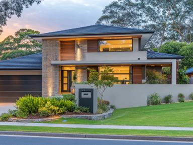 Large two-story home with dark roof, garage, driveway, front lawn, street, sky, trees