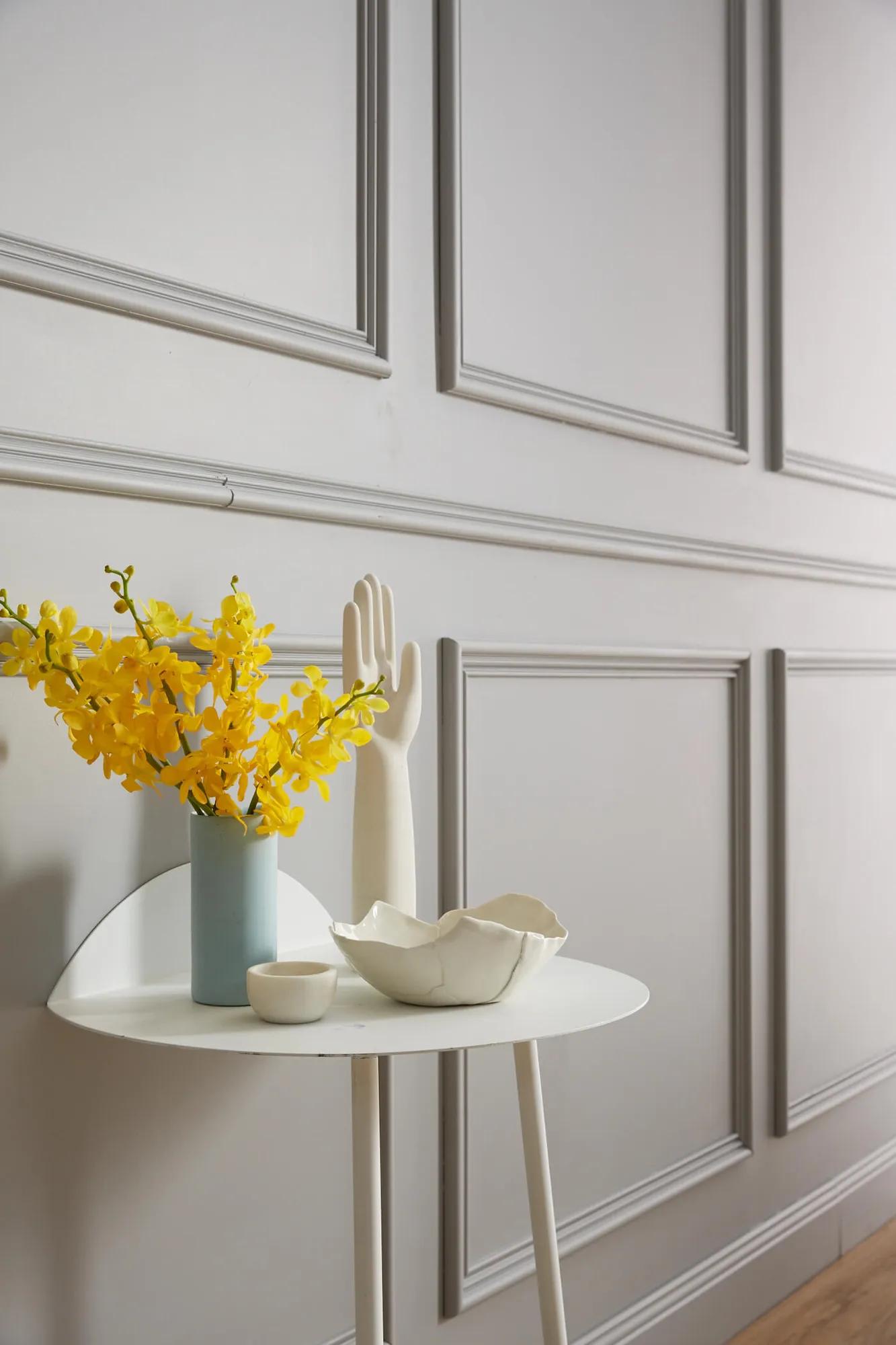 A table with a vase of yellow flowers on it
