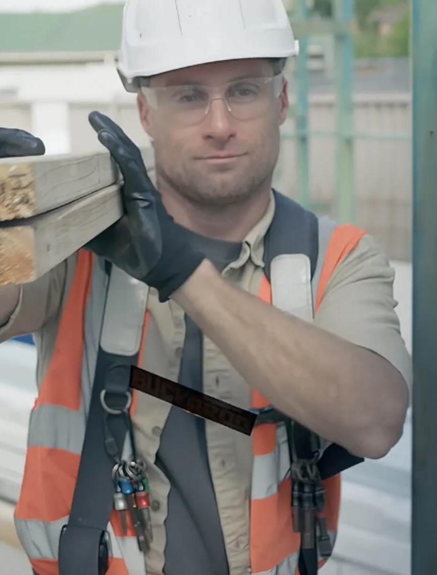 Worker in orange vest with tools building with STRUCTAframe