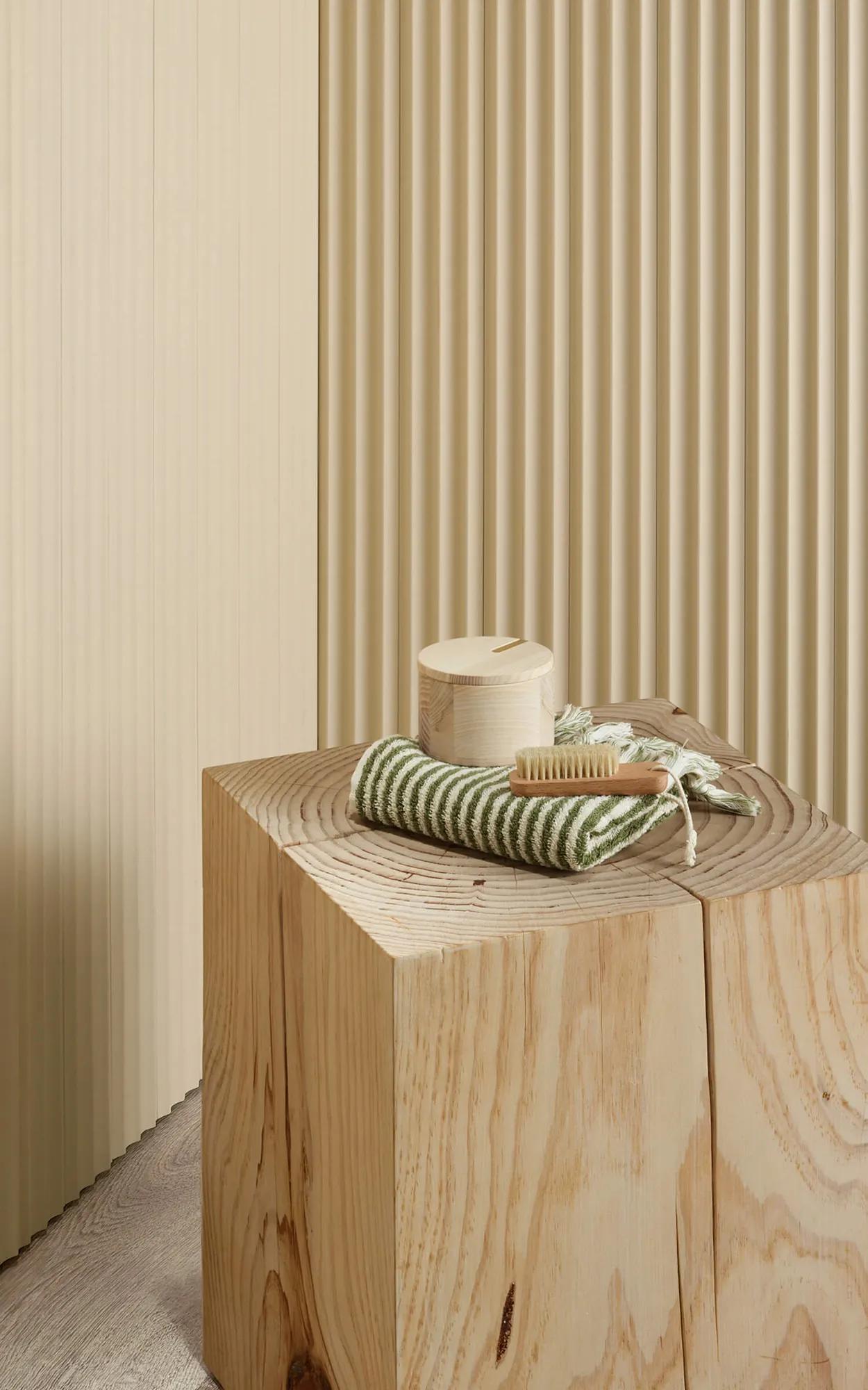 Porta mouldings on wall. Small wooden table. White and green striped box on table
