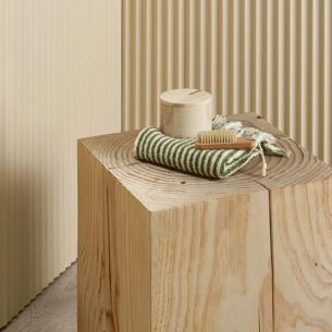 Porta mouldings on wall. Small wooden table. White and green striped box on table