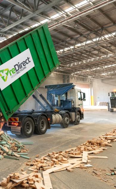 reDirect Wood Recycling truck tipping frame and truss timber waste in warehouse.