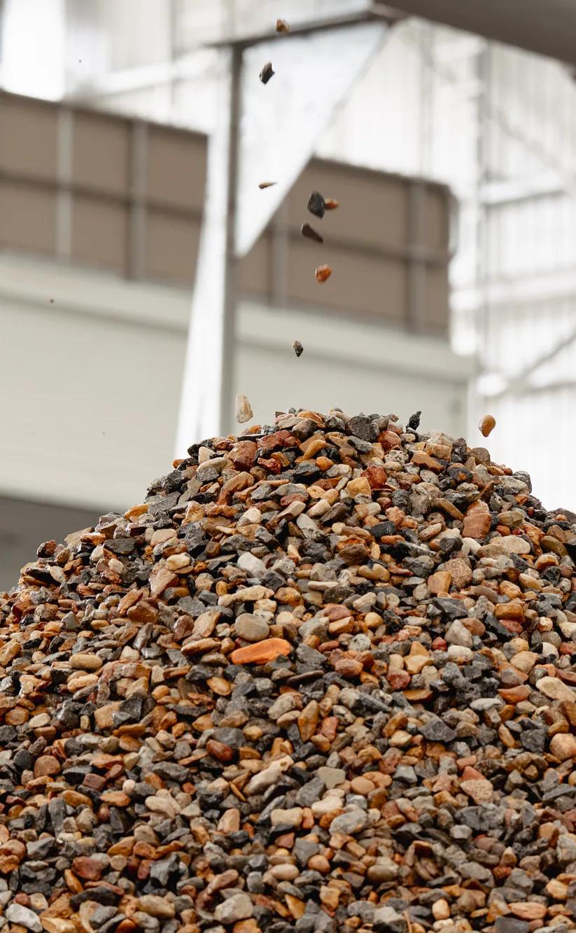 Large pile of recycled aggregate and stone at soil recycling facility.