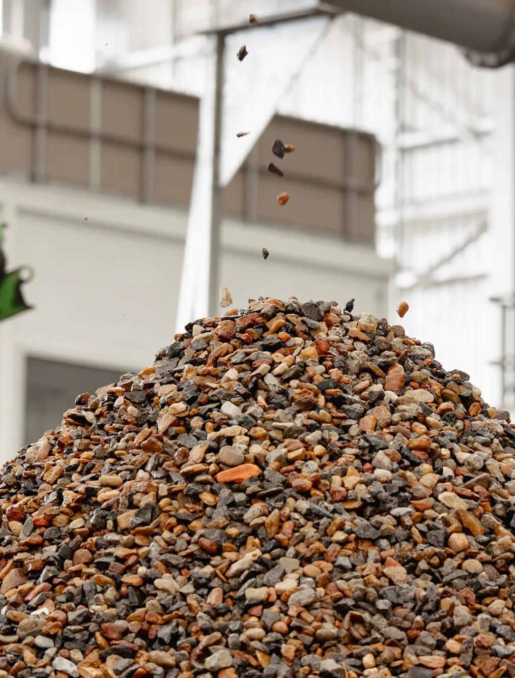 Large pile of recycled aggregate and stone at soil recycling facility.