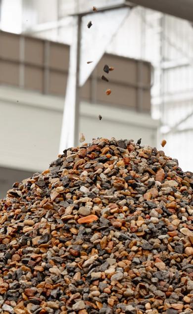 Large pile of recycled aggregate and stone at soil recycling facility.