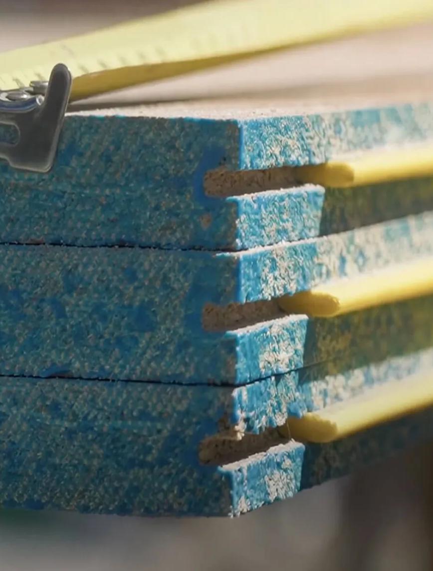 Wooden boards stacked in a horizontal position, indicating construction materials ready for use