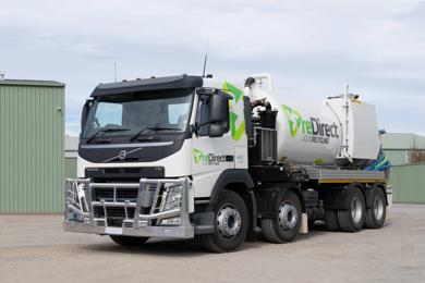 reDirect Liquid Recycling Volvo tanker truck side view outside green shed.