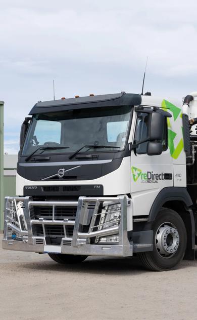 reDirect Liquid Recycling Volvo tanker truck side view outside green shed.