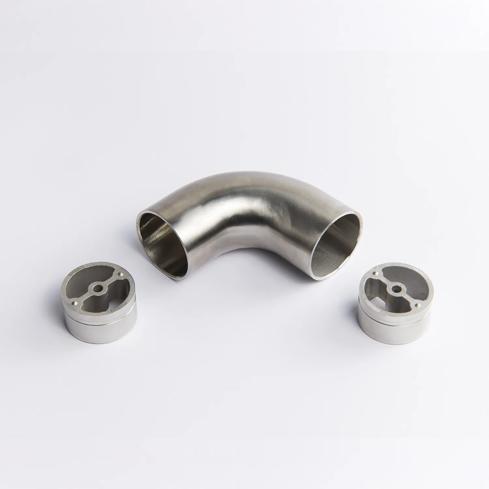 A fixed 90 Degree Stainless Steel metal tube connector positioned between two silver circular mounting inserts 65mm x 43mm
