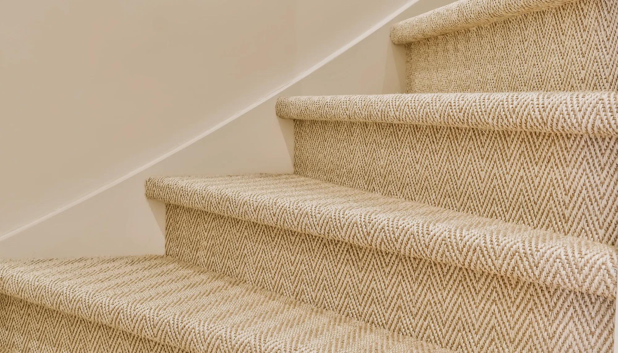 Staircase of beige steps with dark brown carpet