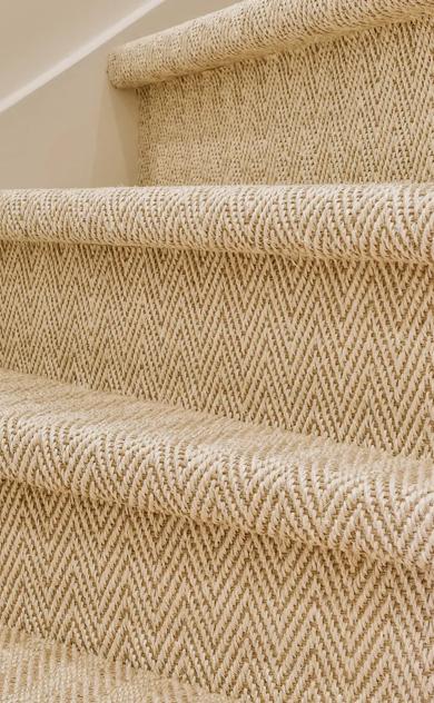 Staircase of beige steps with dark brown carpet